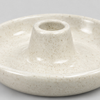 Close up of the speckled glossy glaze across the dish of the ceramic taper candle holder in Speckled Off-White