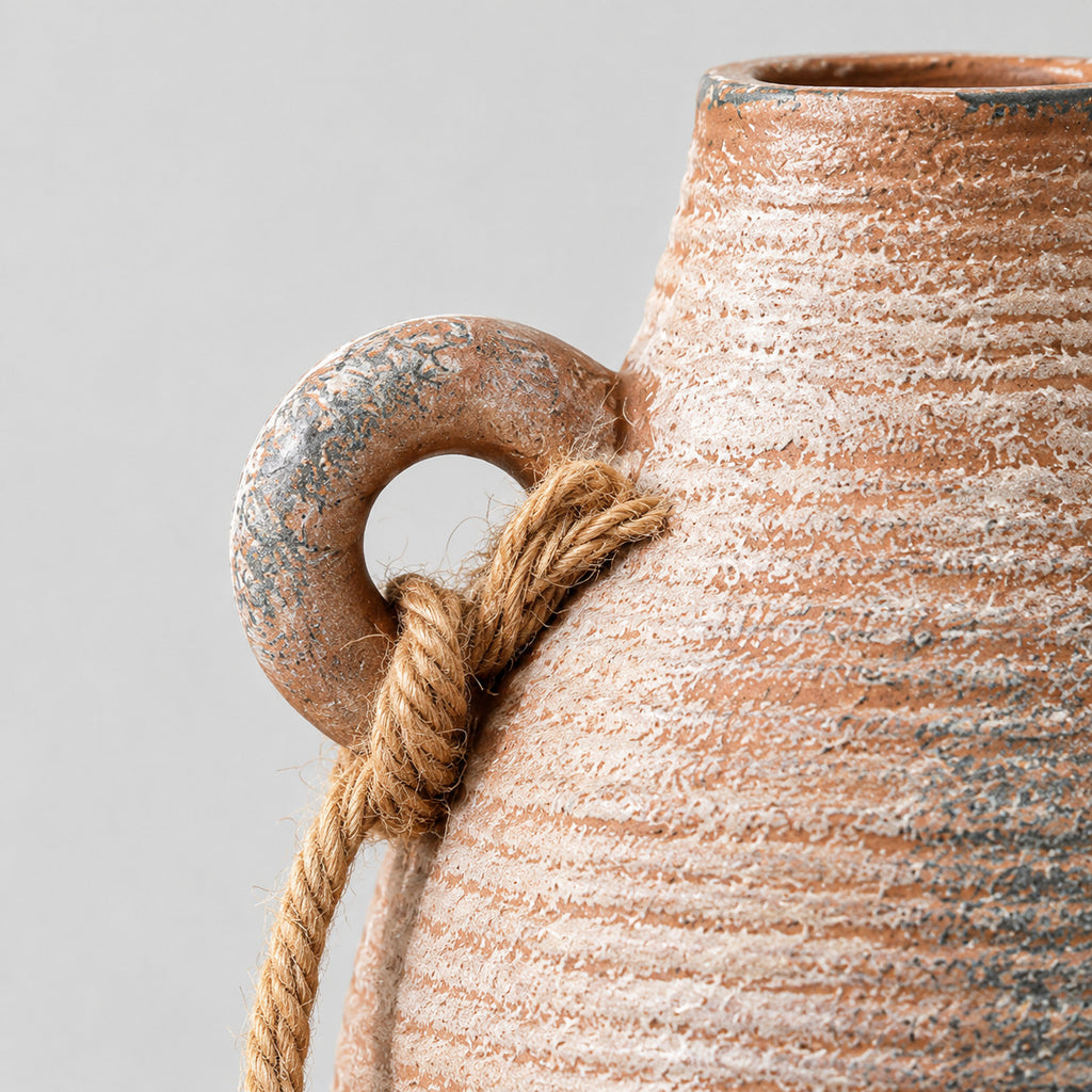 Close up of the looped ceramic handle with knotted jute rope of the ribbed ceramic vase in Rust.