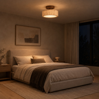 Travertine drum flush mount ceiling light lit in the evening on the ceiling of a bedroom above a 160 cm wide made bed, the only light in the room
