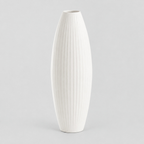Matte white ribbed ceramic vase on a light gray studio background