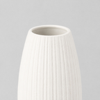 Close up of the smooth rounded rim of the matte white ceramic vase