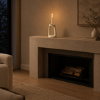 Off-White sculptural ceramic candle holder on a mantelpiece with a lit taper candle.