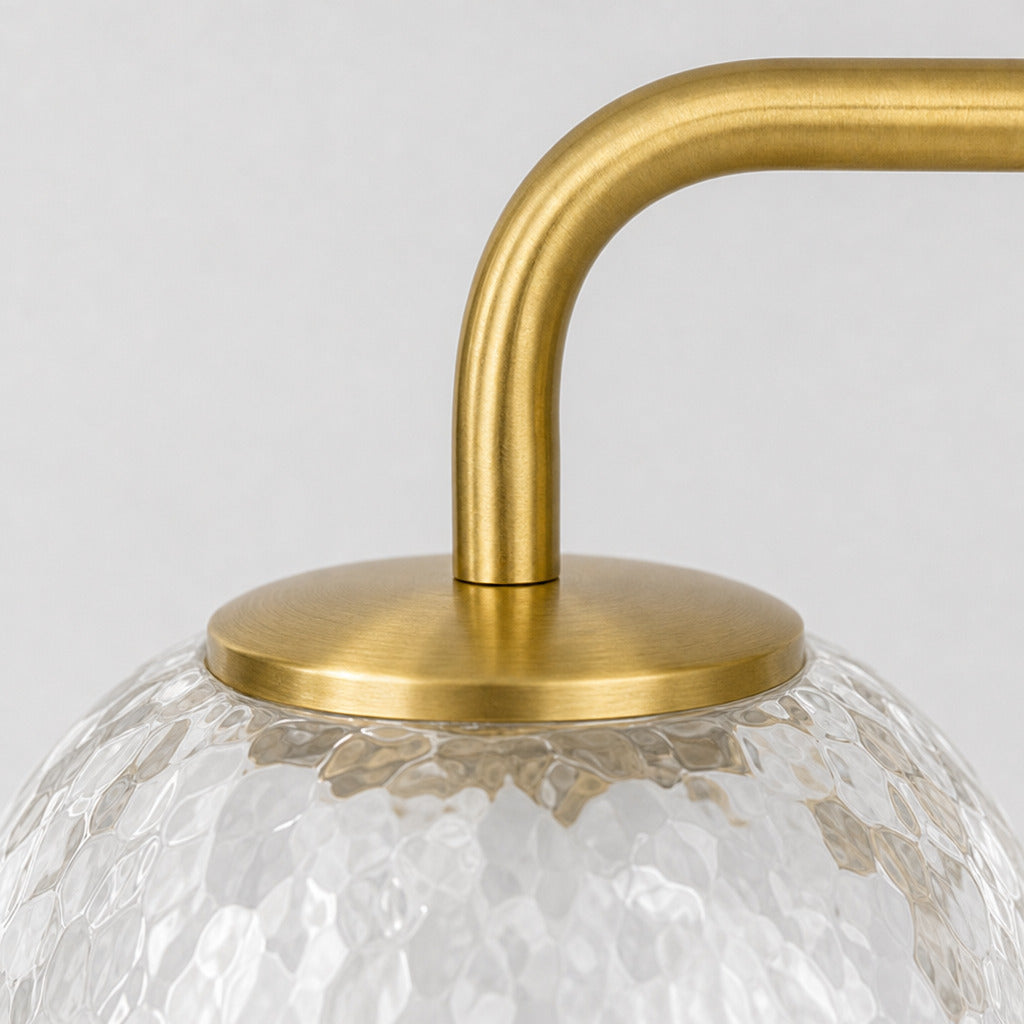 Close up of the rim where the glass shade meets the brass fitter on the brass wall sconce.