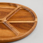 Close up of the smooth curved rim of the three-compartment round wooden serving tray