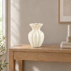 Cream fluted ruffled ceramic vase on a 120 cm wide oak console table in a calm room.