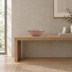 Blush shallow glass bowl on a 120 cm wide oak console table in a calm room.