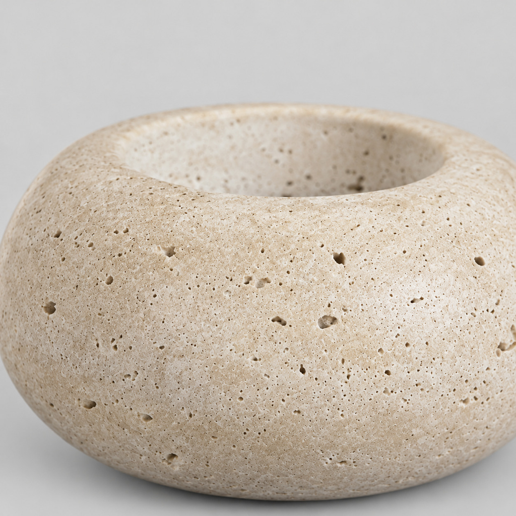 Close up of the pitted natural stone surface texture of the travertine candle holder.