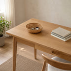 Woven rattan round basket tray in Natural Rattan on a desk with a set of keys and a watch on the tray