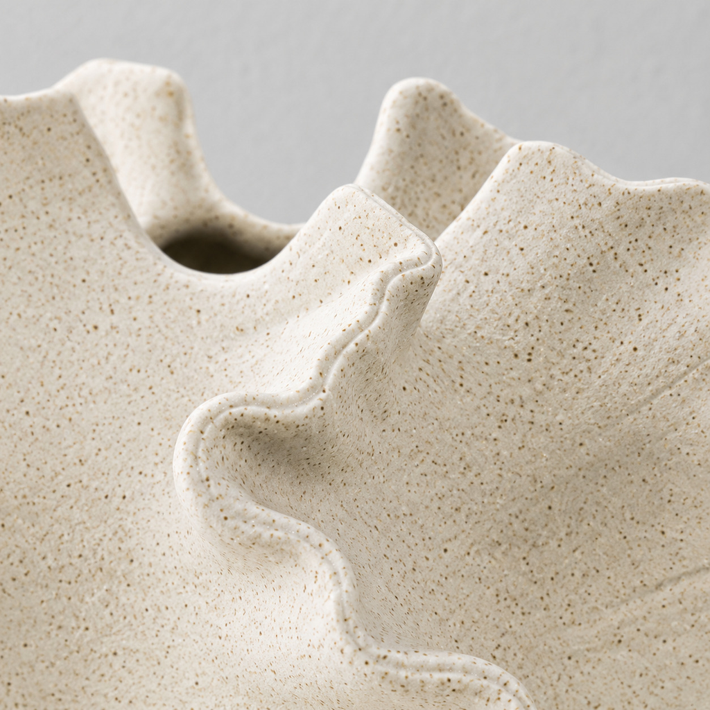 Close up of the speckled matte glaze across the sculptural ceramic wall of the vase in Speckled White