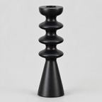 Matte black turned beechwood taper candlestick on a light gray studio background