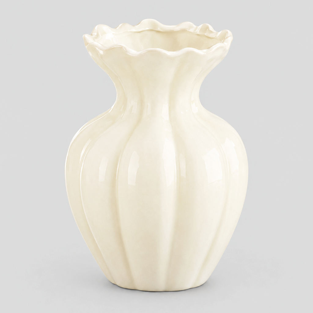 Cream fluted ruffled ceramic vase alone on a light neutral gray studio background.