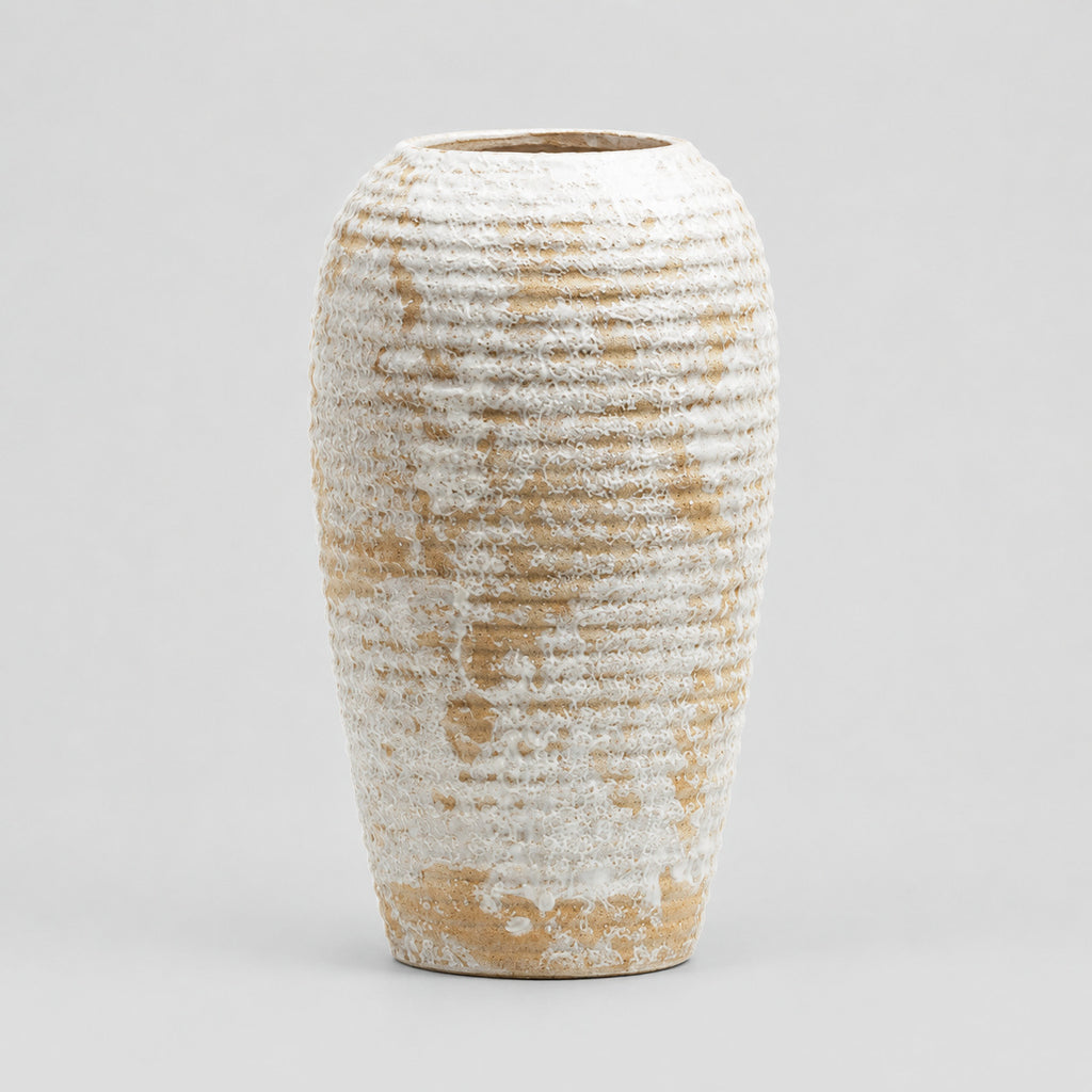 Ribbed barrel ceramic vase in Distressed White on a light neutral gray studio background.