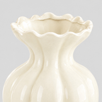 Close up of the undulating ruffled rim of the cream fluted ceramic vase.