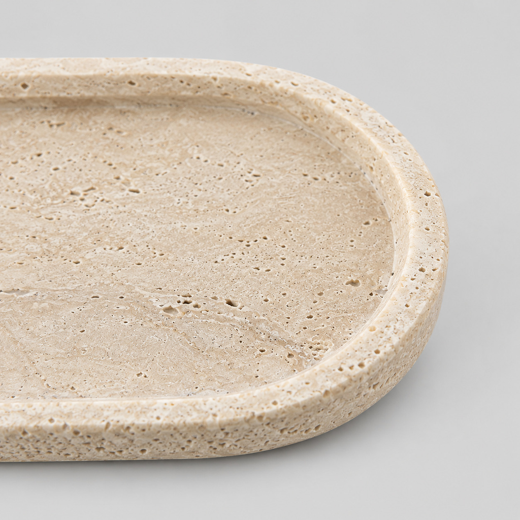 Close up of the smooth rounded rim of the oval travertine tray.