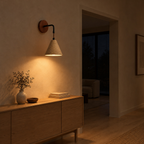 Conical travertine wall sconce in Travertine lit in the evening on a hallway wall beside an 80 cm wide doorway, the only light in the room