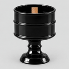 Glossy Black ceramic pedestal candle vessel on a light gray studio background.