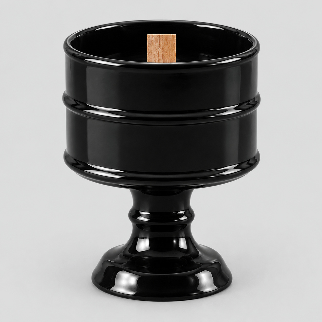 Glossy Black ceramic pedestal candle vessel on a light gray studio background.