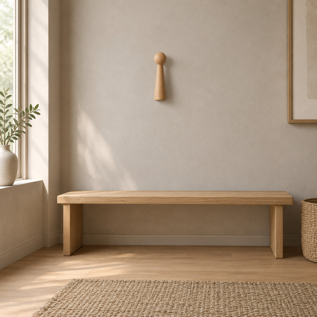 Turned beech wood wall peg in Natural Beech mounted on a greige plaster wall above a 120 cm wide low bench in a calm room.