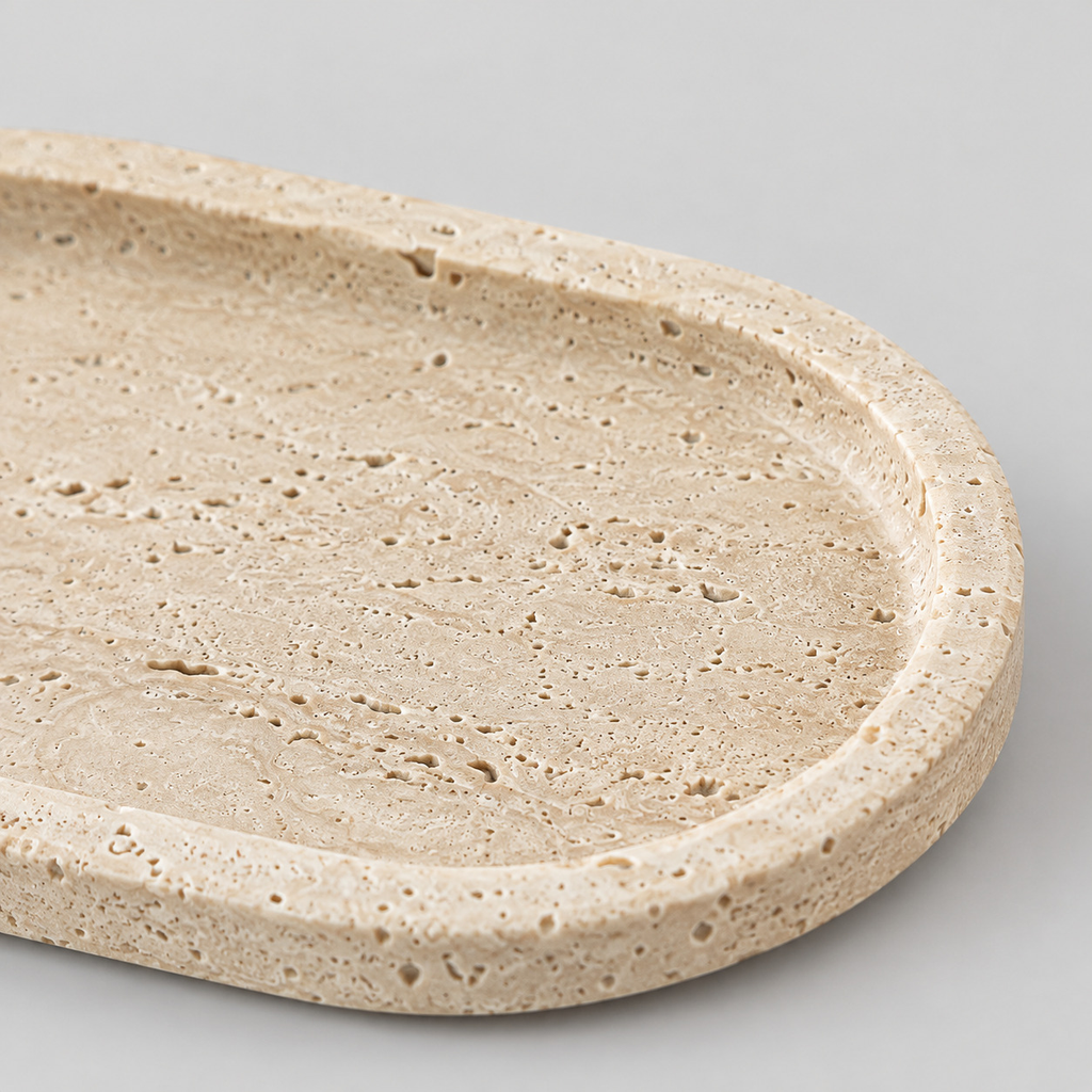 Close up of the porous pitted surface texture of the oval travertine tray.