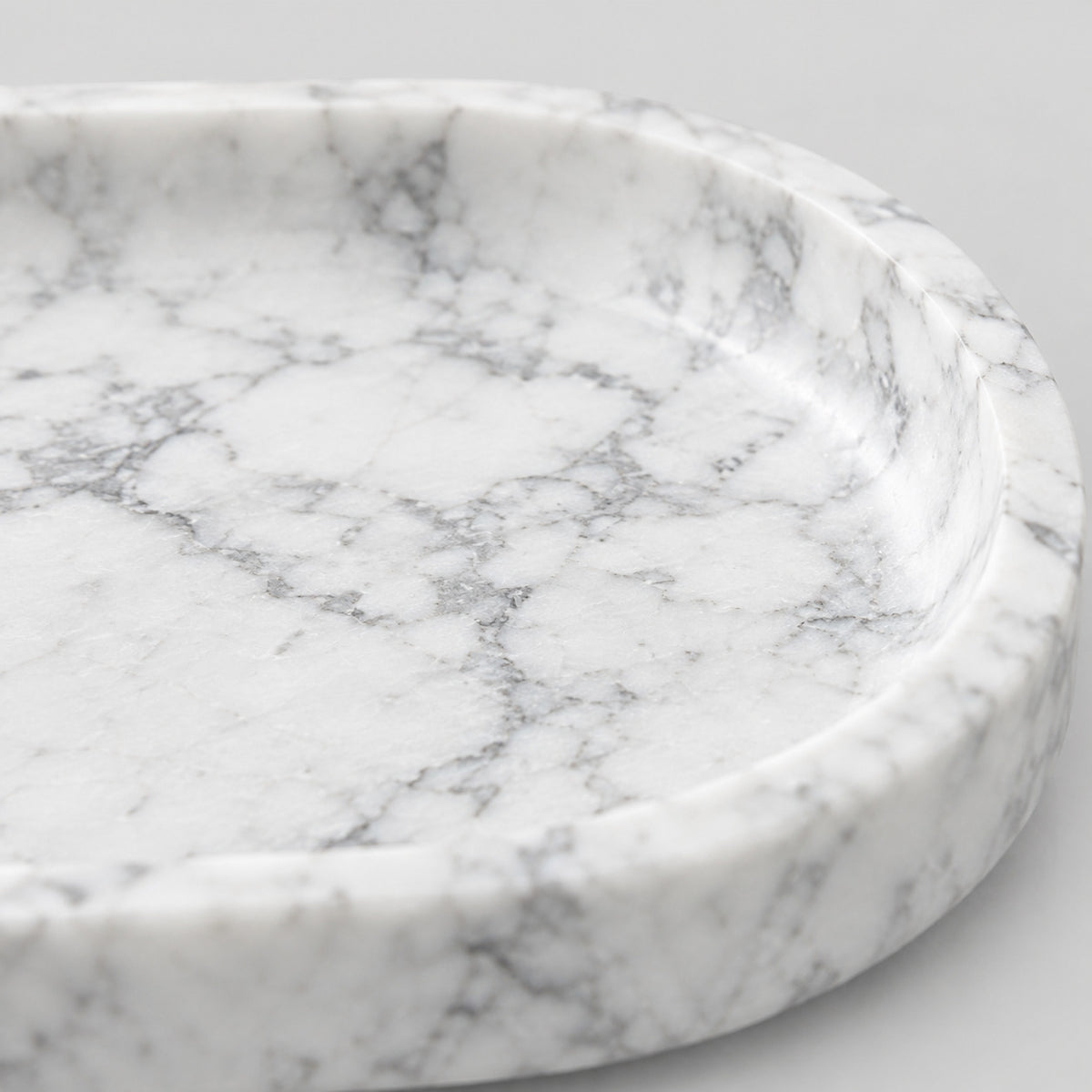 Close up of the flat stone base of the oval stone catchall tray in Carrara White.