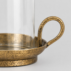 Close up of the curved loop handle on the brass base of the hurricane candle holder.