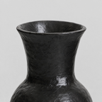 Close up of the flared lip at the rim of the black ceramic vase.