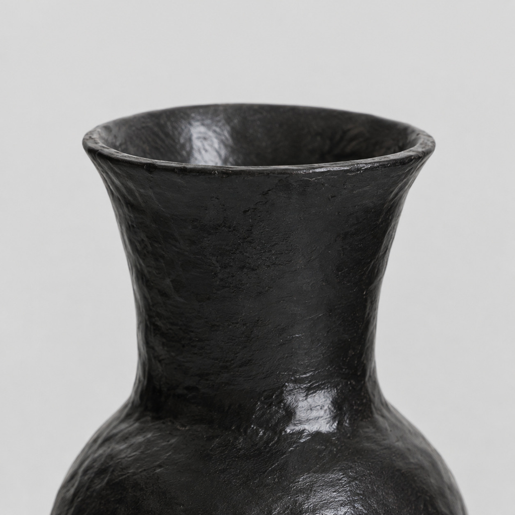 Close up of the flared lip at the rim of the black ceramic vase.