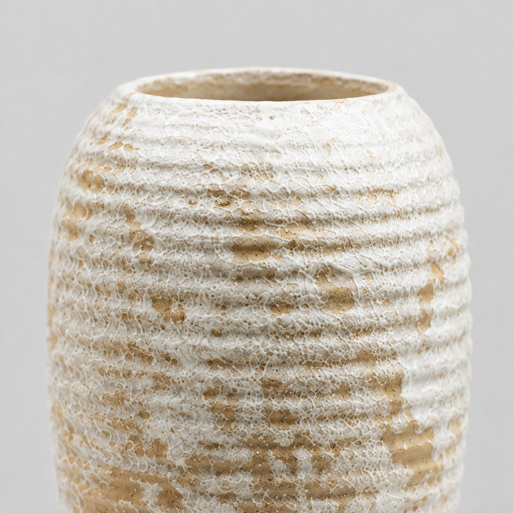 Close up of the distressed white glaze texture across the horizontal ribs of the ribbed barrel ceramic vase in Distressed White.