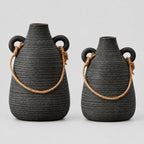 Ribbed ceramic vase with loop handles in Weathered Black on a light gray studio background.