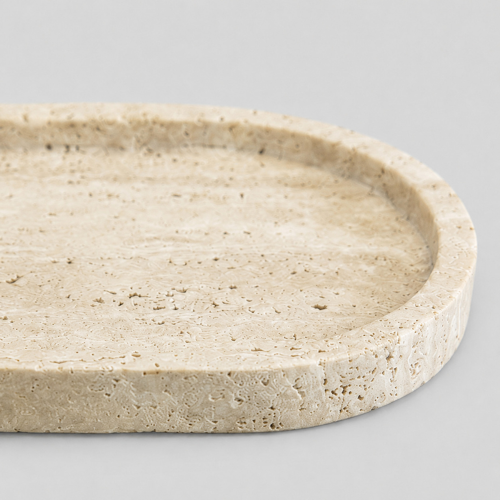 Close up of the porous travertine surface texture of the oval stone vanity tray in Beige Travertine