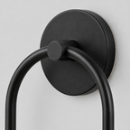 Close up of the round canopy against the wall of the Matte Black asymmetric double-globe arch wall sconce.