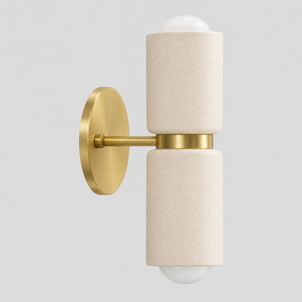 Dual-light ceramic wall sconce in a brass finish on a light gray studio background