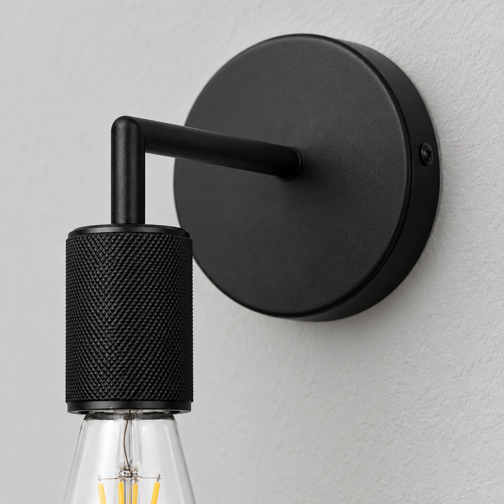 Close up of the round canopy against the wall of the Matte Black knurled socket wall sconce