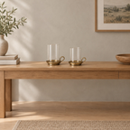 Set of two brass hurricane candle holders in Antique Brass on an oak console table in a calm room.