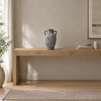 Weathered gray ceramic amphora vase on an oak console table in a calm room