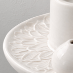 Close up of the embossed petal pattern across the dish of the white ceramic incense and candle tray