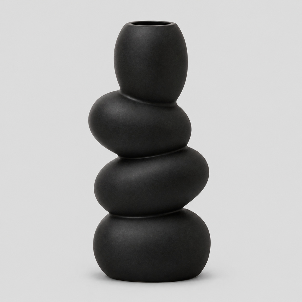 Black stacked pebble ceramic vase on a light gray studio background.