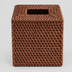Brown rattan cube tissue box cover on a light gray studio background.