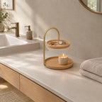 Two-tier round wooden serving tray in Beech on a bathroom vanity with a set of keys and a watch on the tray.