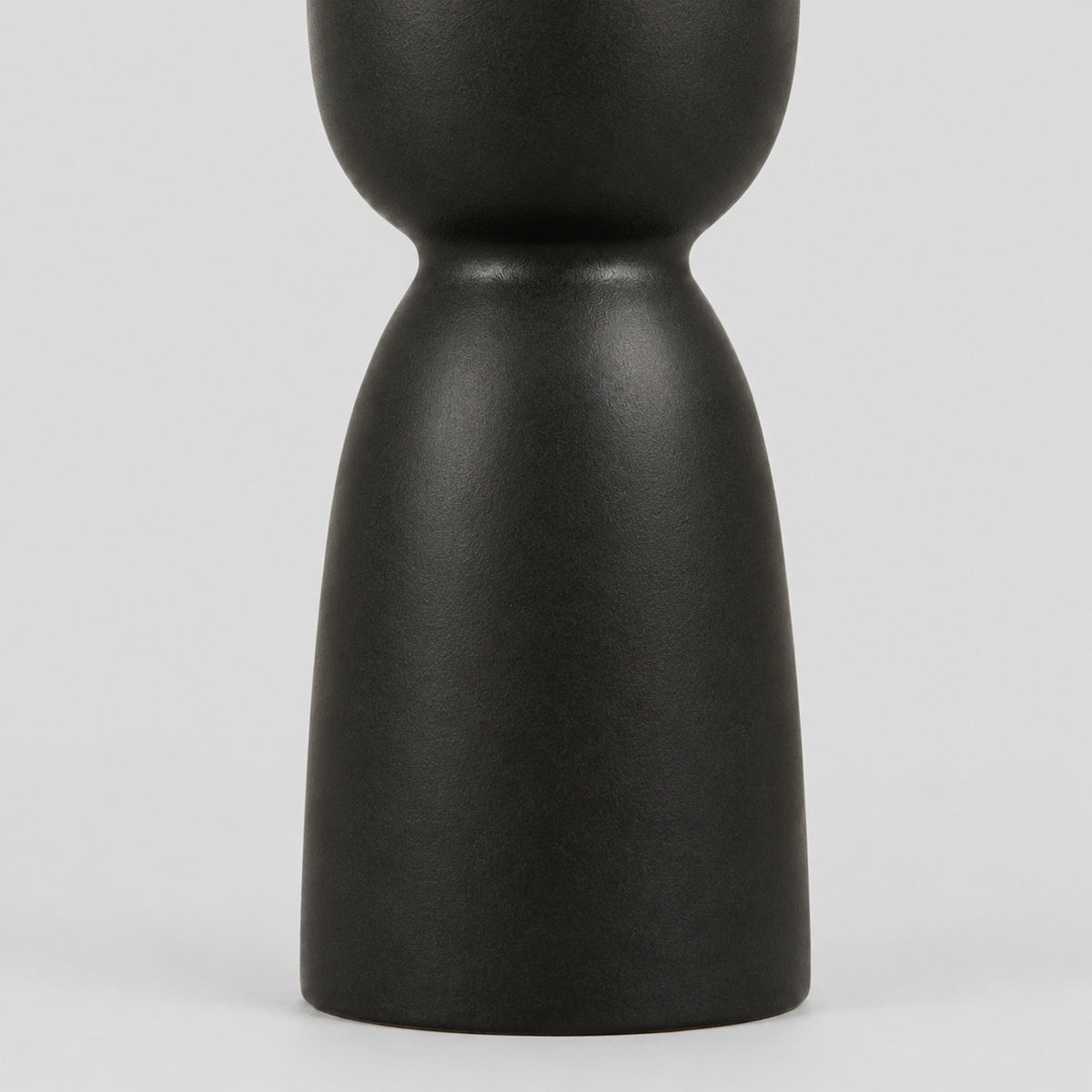 Close up of the pedestal base of the matte ceramic taper candle holder.