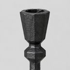 Close up of the faceted rim of the candle cup on the matte black cast-iron taper candle holder.
