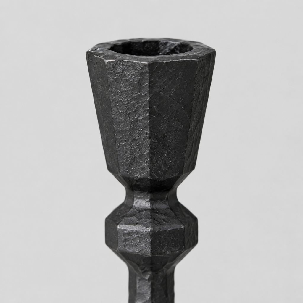 Close up of the faceted rim of the candle cup on the matte black cast-iron taper candle holder.