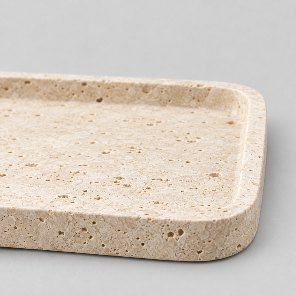 Close up of the naturally pitted surface texture of the rectangular travertine catchall tray in Beige Travertine.