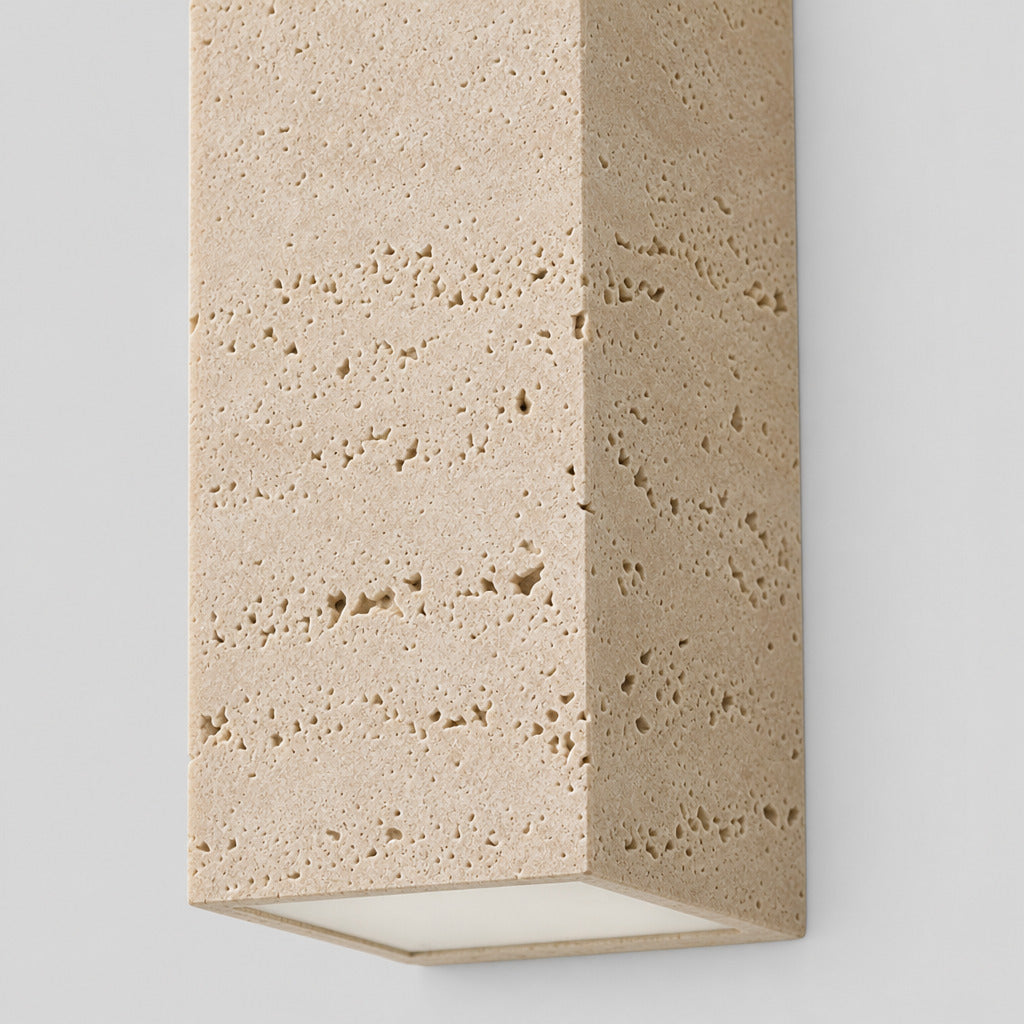 Close up of the natural pitted face of the yellow travertine block wall sconce