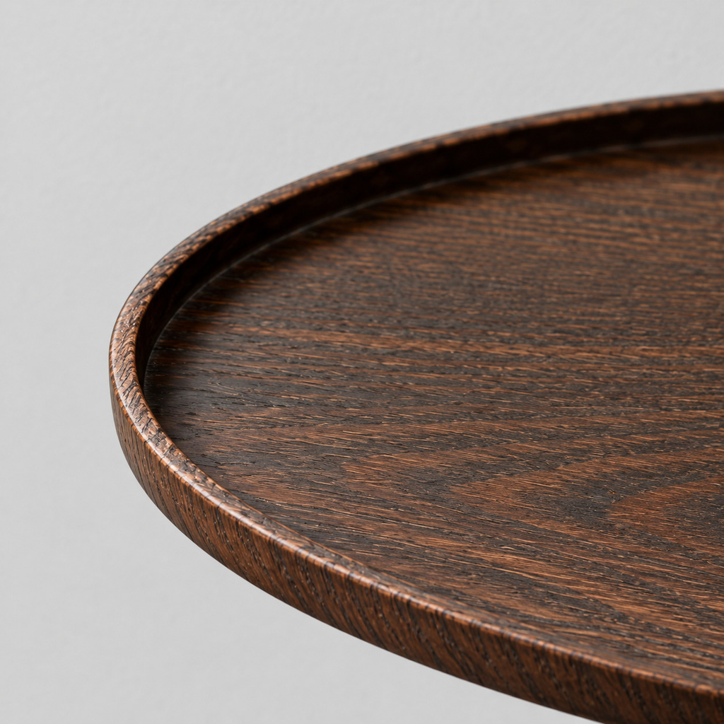 Close up of the smooth curved rim of the oval dark ash wood serving tray
