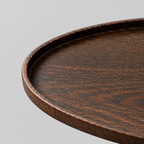 Close up of the smooth curved rim of the oval dark ash wood serving tray