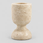 Carved travertine pedestal candle holder in Travertine finish on a light gray studio background.
