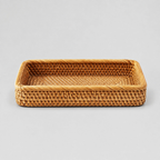 Natural rattan handwoven rectangular tray on a light gray studio background.