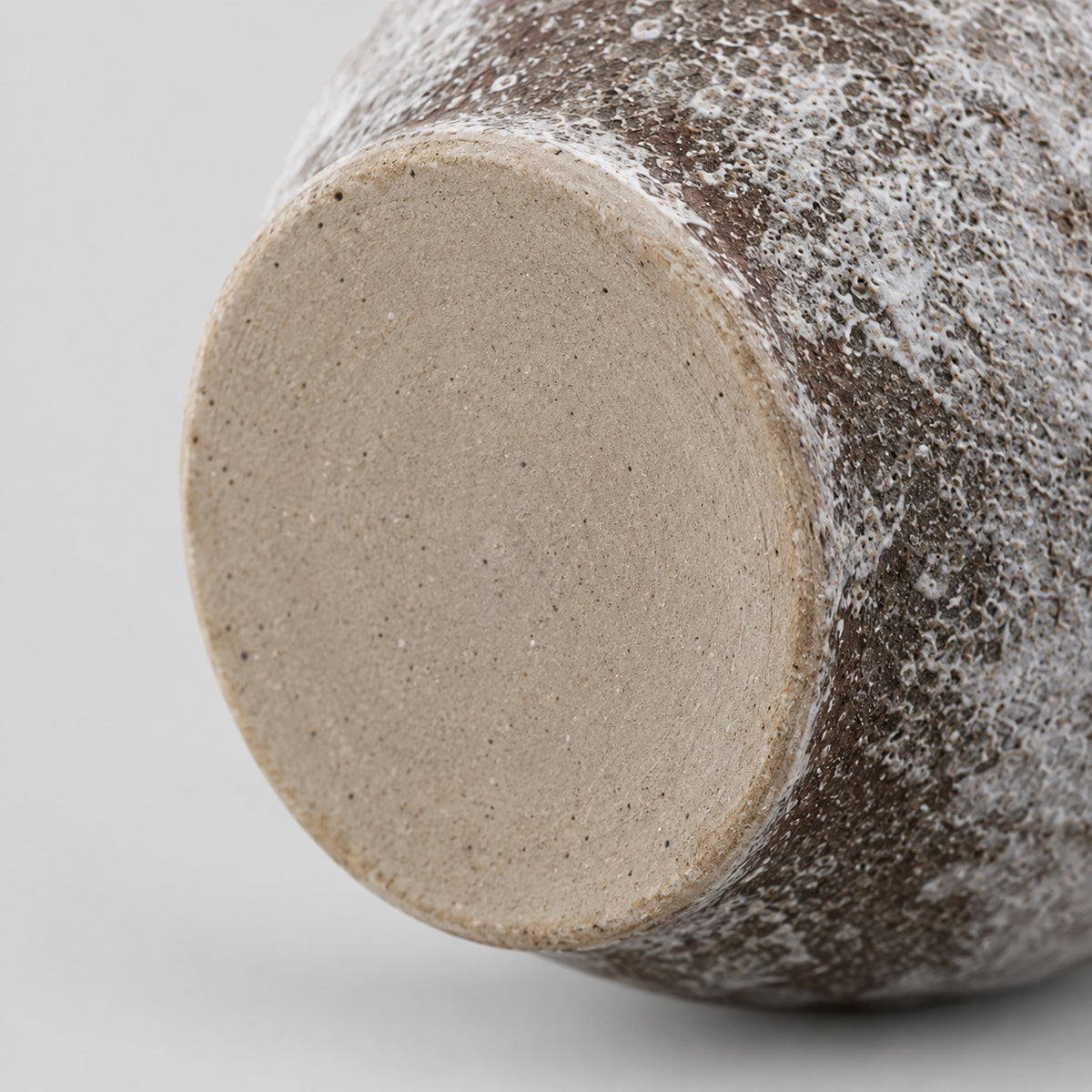 Close up of the unglazed flat foot of the weathered ceramic vase in Weathered Brown.