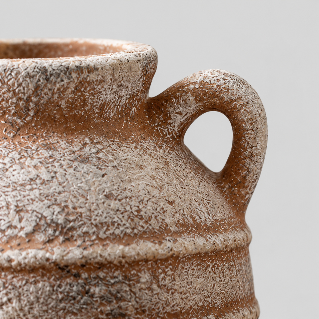 Close up of the small looped ceramic handle of the double-handled ceramic amphora vase.